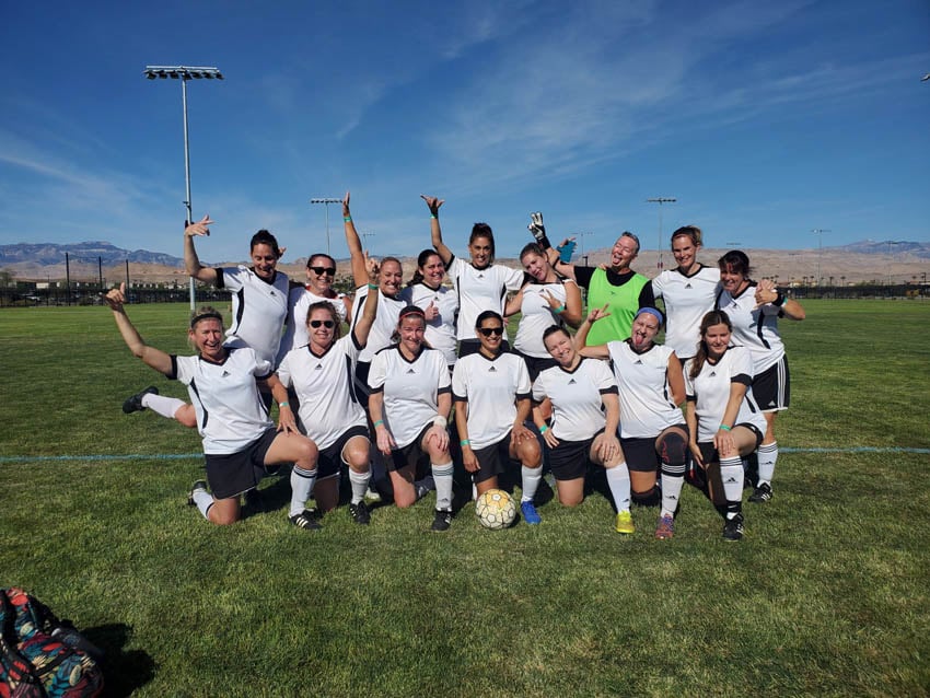 female soccer team poses goofily in group