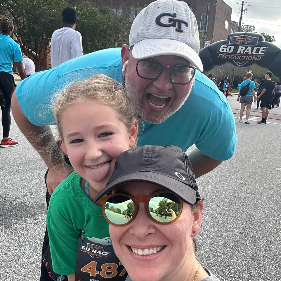 John Moore's family photo with wife and 8-year old daughter at a 5k race taking a selfie together