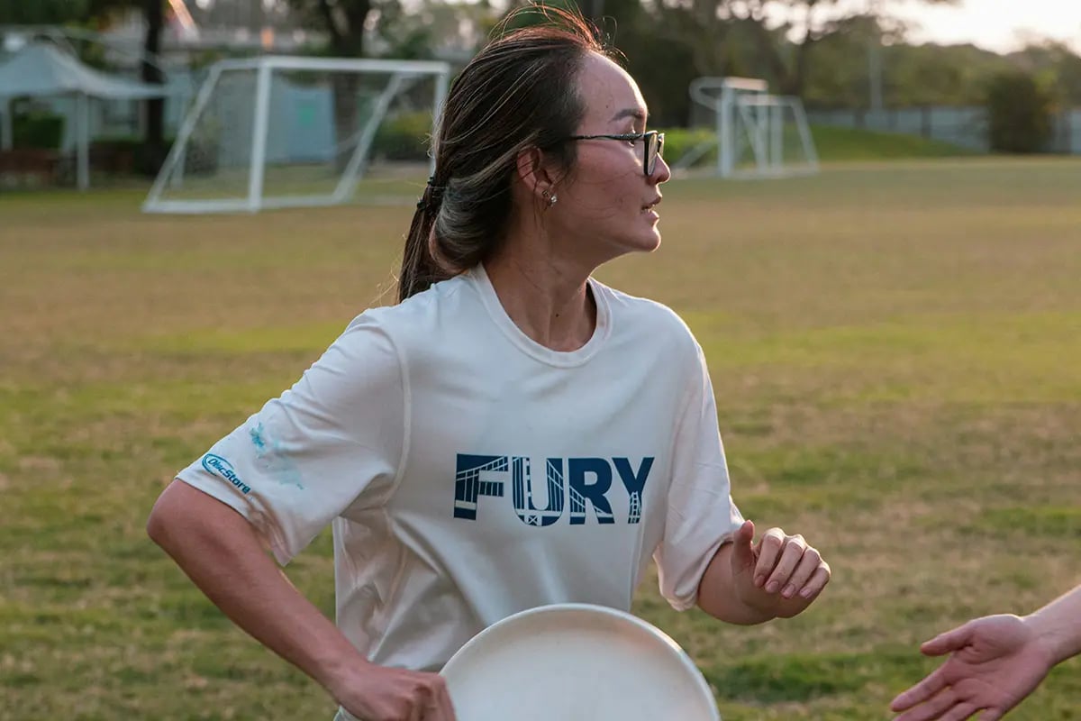 woman holding ultimate disc on field