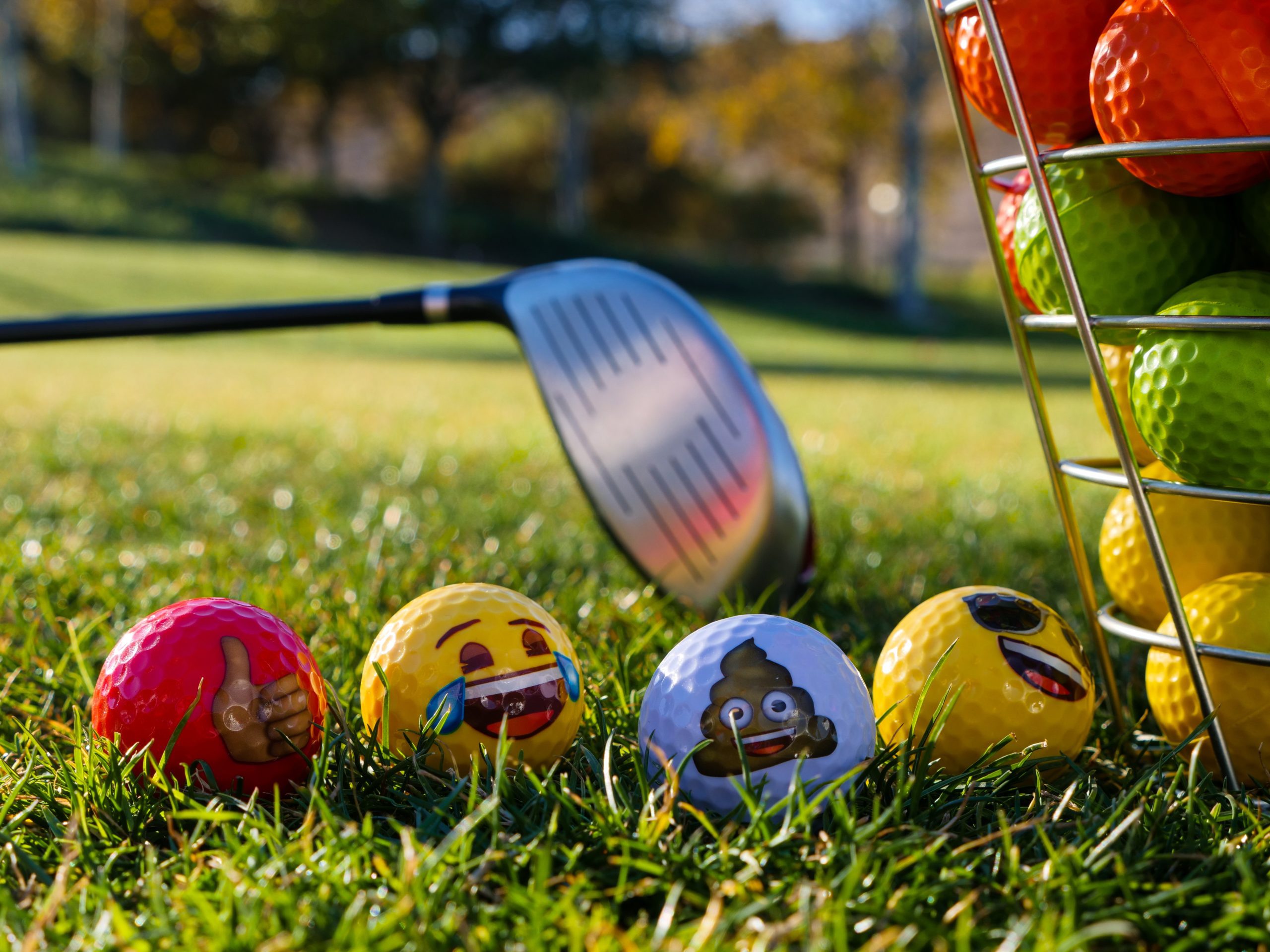 golf balls with emojis on grass