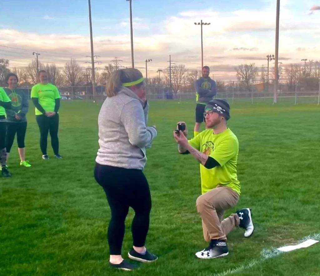 man proposing to woman on flag football field
