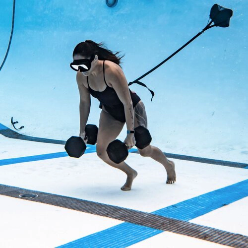 Woman carrying weights at bottom of pool
